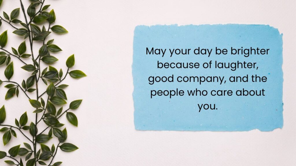 Light blue paper note next to green leaves sharing a positive message to make it a great day.