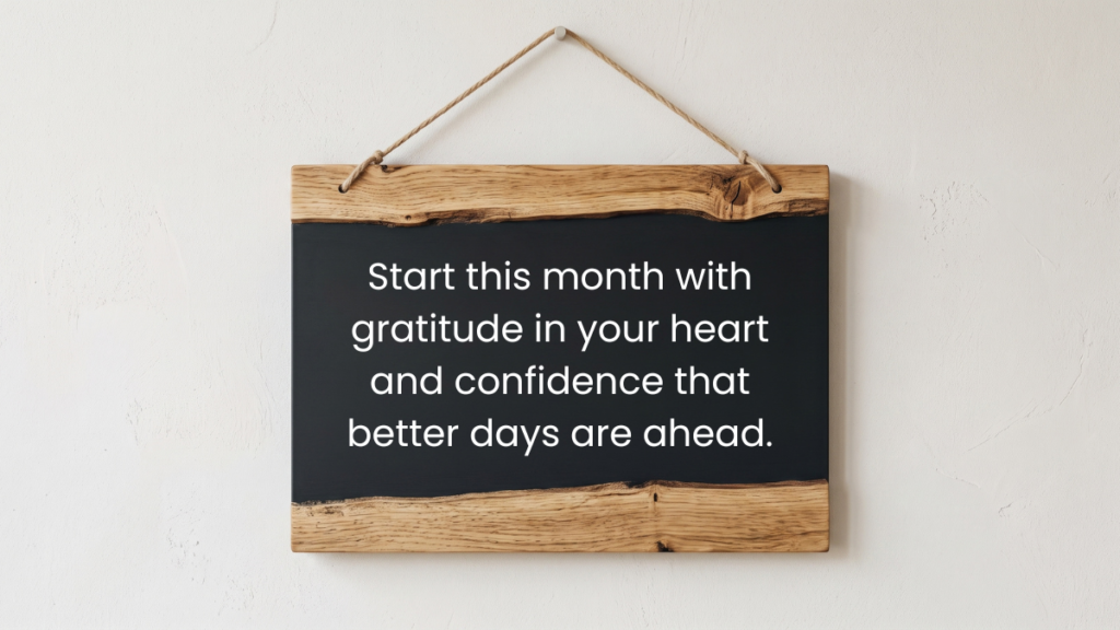 A rustic wooden hanging chalkboard sign displaying thoughtful new month quotes on a wall.