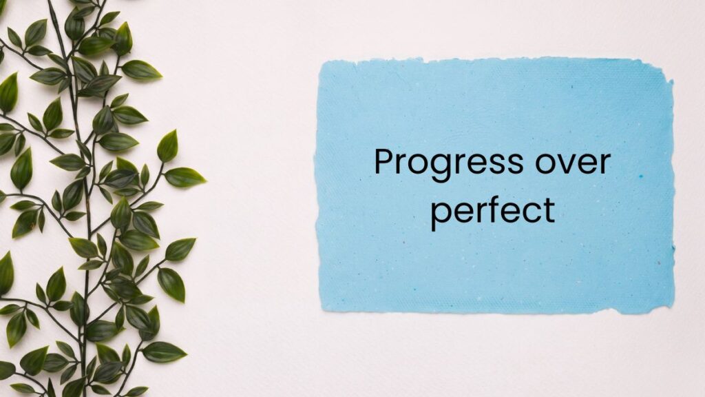 Blue paper note next to green leaves displaying tuesday motivational quotes for work.